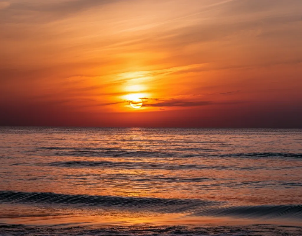 Serene Sunset over the Ocean - A peaceful and calming sunset over the ocean, with vibrant orange and pink hues spreading across the sky and reflecting on the gentle waves. - AI image generated with Imagen 3
